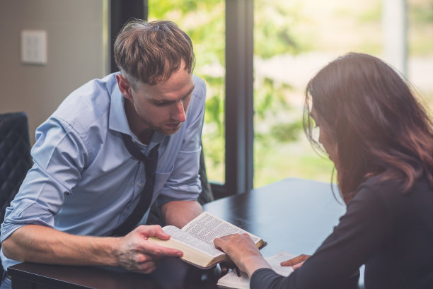 基督教男女在饭桌上一起学习圣经。图片下载