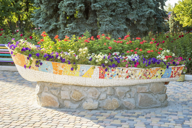 街上放了一大盆花。街花在一个石头壶的形状的船图片下载