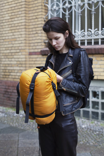 一个小女孩带着她的睡袋和背包旅行图片下载