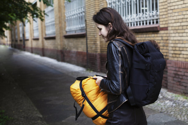 一个小女孩带着她的睡袋和背包旅行图片下载