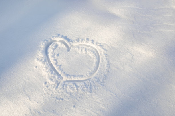 雪上心形的图案。特写镜头。幸福浪漫的形象。图片下载
