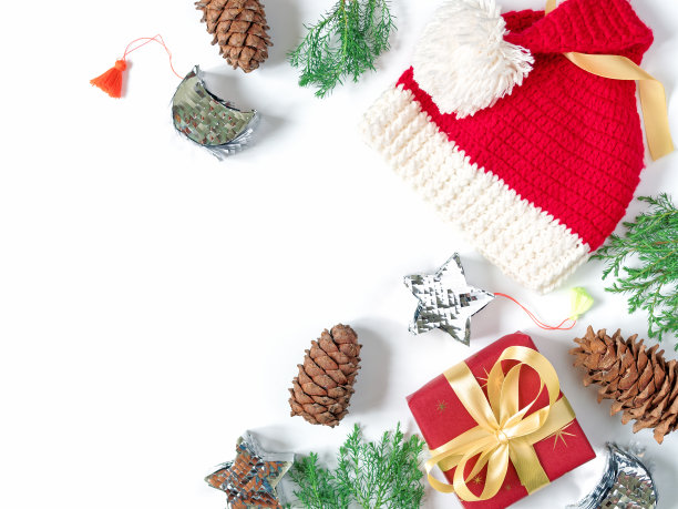 圣诞节的布局。用红色包装纸包裹的礼物是用黄色的丝带和一个蝴蝶结绑起来的。附近是圣诞老人的帽子，树枝上有绿色的针，闪亮的亮片装饰品和松果。本空间图片下载