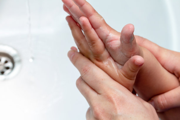 女人在水龙头下帮助孩子洗手图片下载