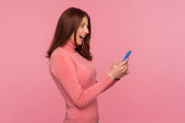 头像开心兴奋的黑发女子在智能手机上看短信带着震惊惊讶的表情，想知道是否有良好的网络连接图片下载