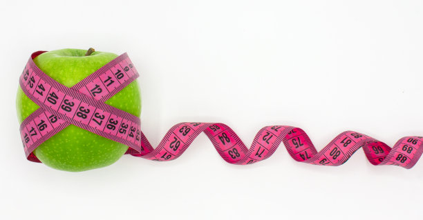 一个青苹果和粉红色的卷尺图片下载