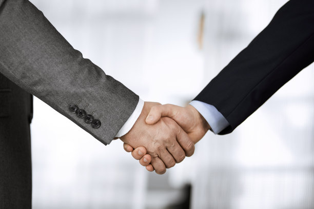 商务人士穿着西装站着握手，特写。商务沟通的概念。握手和营销图片下载