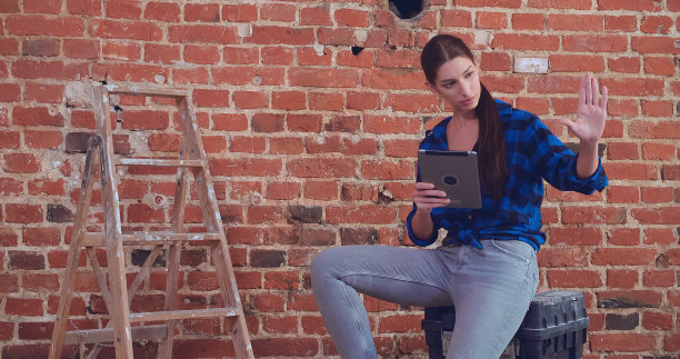 年轻女子用平板电脑规划她的公寓内部。做白日梦图片下载