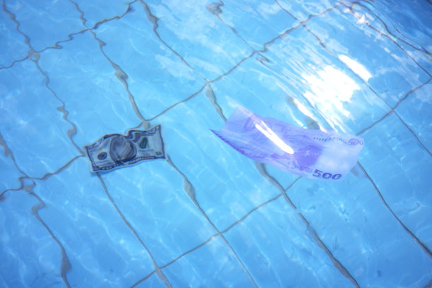 欧元和美元钞票在清澈的蓝色海水上游泳图片下载