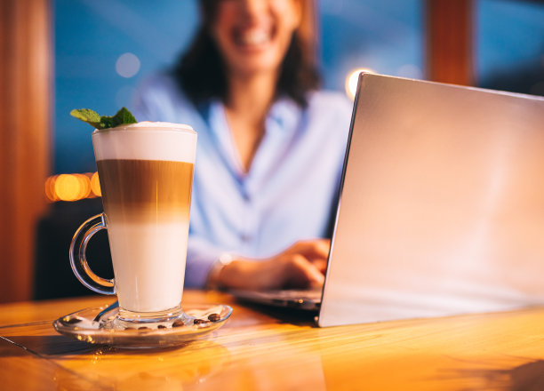 远程工作。年轻女子拿着笔记本电脑喝咖啡图片下载