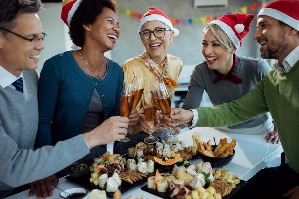 在办公室的新年聚会上，愉快的同事们喝着香槟畅饮。图片下载