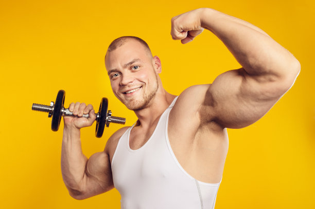 一个带着哑铃的肌肉男的工作室肖像图片下载