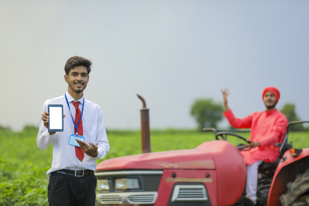 年轻的印度农学家在田间展示智能手机或平板电脑图片下载