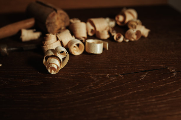 木匠工作的桌子上有工具和工艺品，木桌上有木屑和工具。图片下载