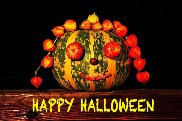 万圣节快乐-文字与装饰南瓜木制表面-秋天的象征，在黑暗的背景。秋天的概念，收获，万圣节。图片下载