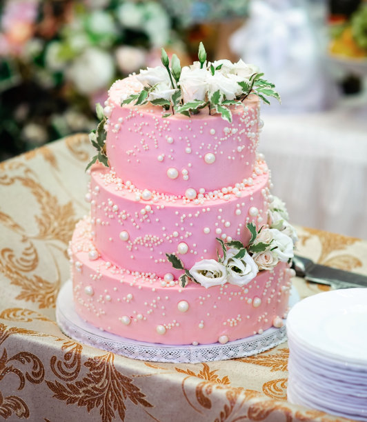粉红色的婚礼蛋糕，装饰着水钻和鲜花。图片下载