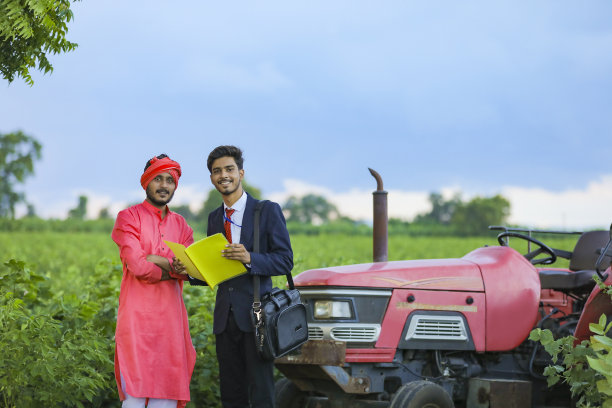 年轻的印度银行职员在田地里向农民展示贷款文件的细节图片下载