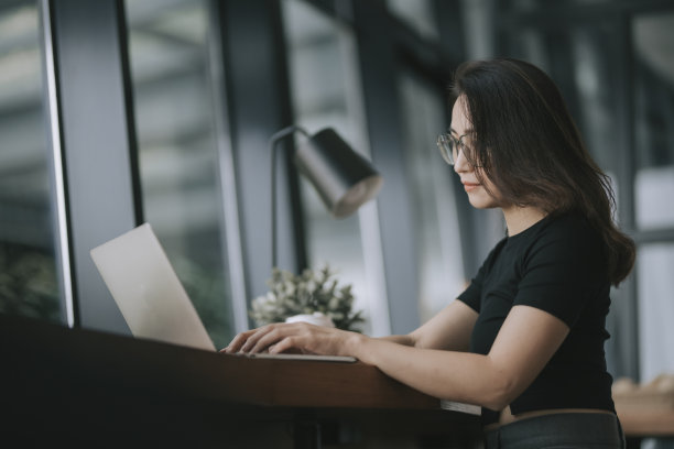 亚洲中国美丽的女人坐在角落café工作用笔记本电脑视频会议素材图片