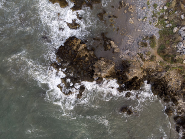空中自上而下的照片，泡沫海浪撞击岩石海岸，海岸线上的大石头。爱琴海，希腊克里特岛的大自然。海洋自然图案，背景壁纸。图片下载