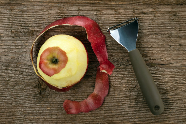 水果和蔬菜切刀与削皮的苹果在粗糙的木制背景图片下载