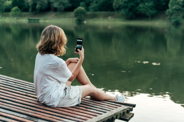 湖上一个拿着电话的女人图片下载