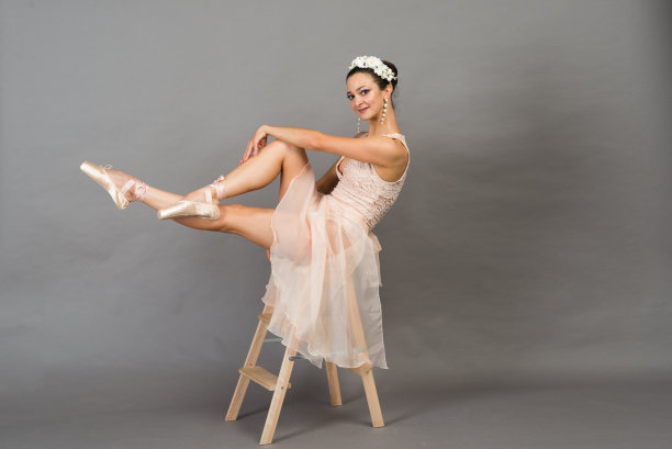 美丽的芭蕾舞者在浅灰色的工作室背景点摆姿势图片下载