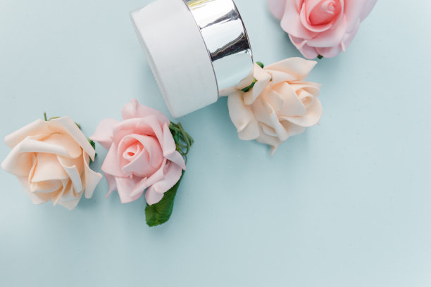 风格美丽的网络横幅。护肤霜，干花，树叶，玫瑰。蜡笔蓝色的桌子背景。有机化妆品，水疗概念。空旷，平坦，俯视图。素材图片