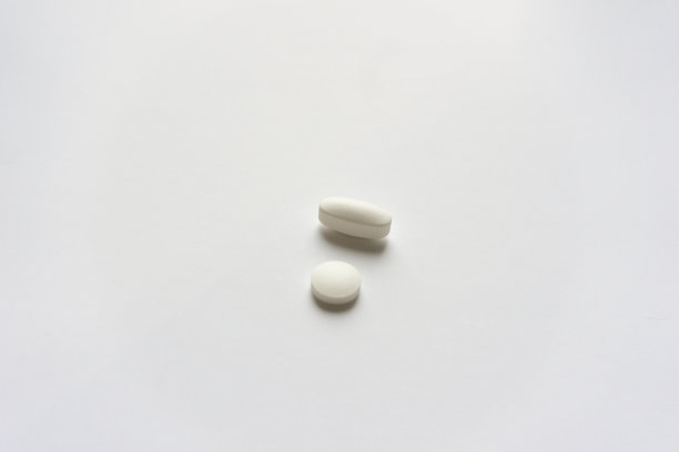 白色的药片和片剂。制药药药。灰色的背景光。图片下载