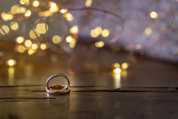 木桌上放着订婚戒指和灯。图片下载