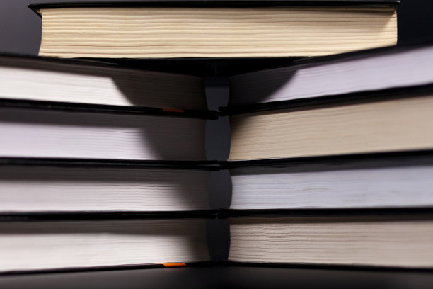 整齐的书在黑暗的背景。特写镜头。侧视图。图片下载