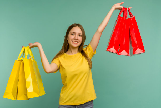 漂亮迷人的女孩的照片，有吸引力的快乐的女孩刚刚结束购物和欣喜若狂，而孤立的蓝色背景图片下载