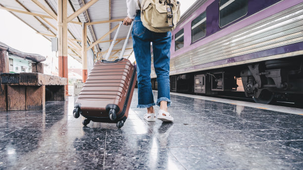 这张照片拍摄的是一个女人的腿在火车站里带着行李走着。图片下载