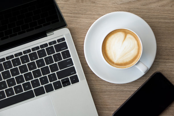 电脑、手机和一杯咖啡放在一张木桌上(俯视图)。经营理念形象图片下载