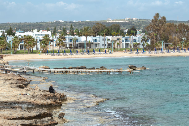 在一个阳光明媚的夏日，地中海海岸上一个渔民的剪影图片下载