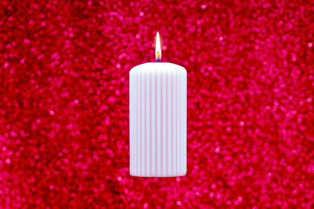 抽象燃烧的蜡烛在粉红色的背景。最小平铺圣诞节或生日主题。新年销售理念。剪下图片下载