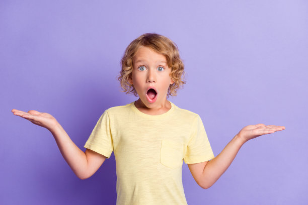 照片惊讶的小男孩手牵手copyspace穿着休闲风格的衣服孤立在紫色的背景图片下载