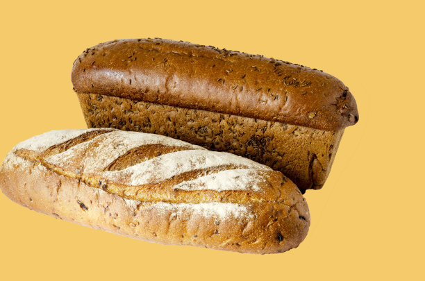 两个随机的黑麦面包面包在浅棕色的背景。图片下载