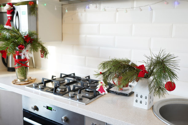 白色现代厨房装饰圣诞节。花盆里的小圣诞树，白色的陶瓷砖墙背景，红色的圣诞玩具图片下载