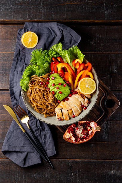 健康佛碗午餐-荞面与鸡肉，鳄梨和蔬菜在一个黑暗的背景，俯视图，垂直照片图片下载