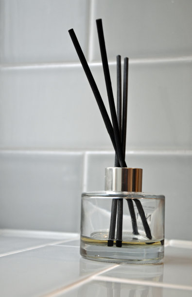 灰色瓷砖架子上的香水扩散瓶图片下载