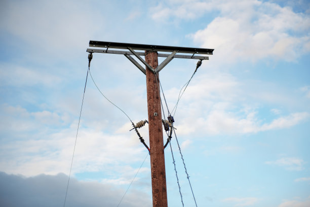 支撑电缆和绝缘子的木杆，映衬着蓝天白云图片下载