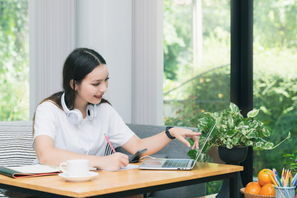 年轻的学生在线观看课程，并在家里学习。她使用笔记本电脑和在线学习。远程学习在线教育。图片下载