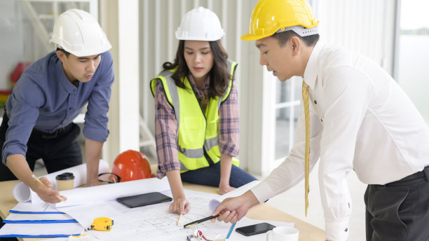 工程人员是分析建设计划和蓝图在办公室图片下载