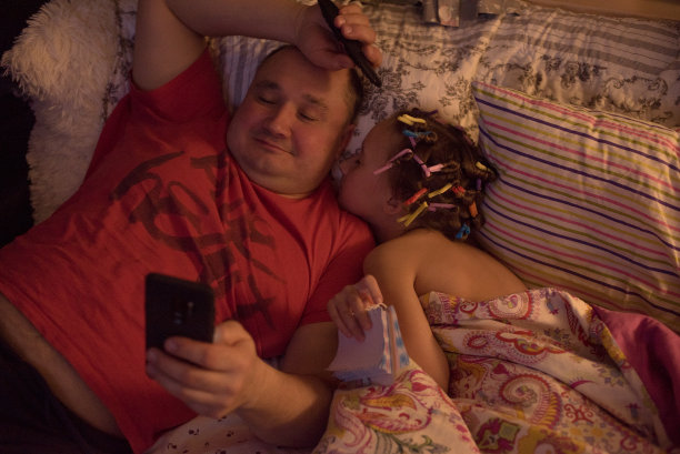 爸爸哄女儿上床睡觉。图片下载