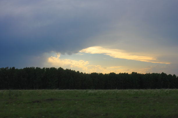 黑暗的夏季日落在草地上，村庄日落图片下载