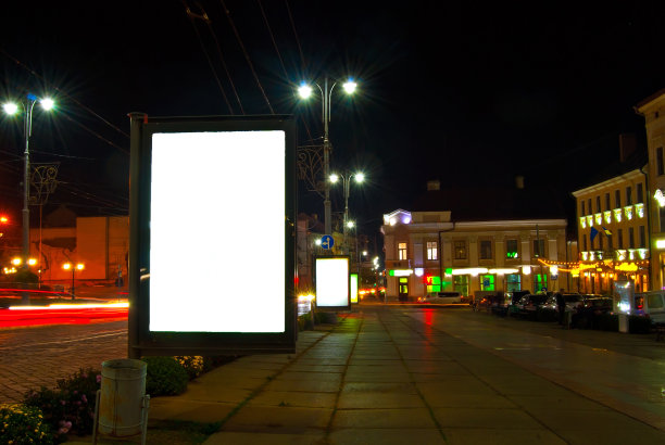 夜色城市背景上的空白招牌。设计的模型。免费的广告空间。图片下载