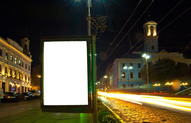 夜色城市背景上的空白招牌。设计的模型。免费的广告空间。图片下载