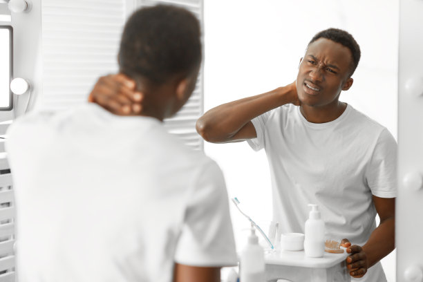 非洲男子触摸疼痛的脖子在浴室遭受疼痛图片下载