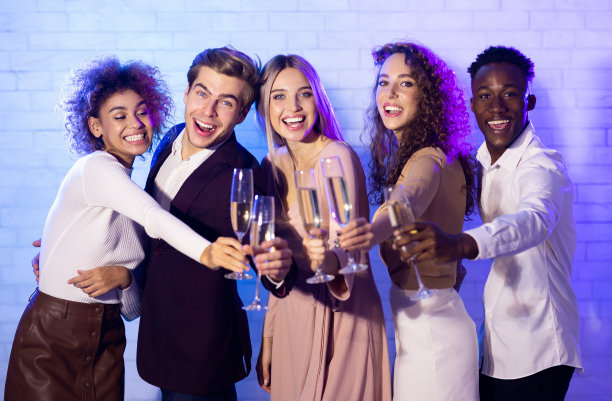 年轻人在室内聚会，举杯畅饮香槟图片下载