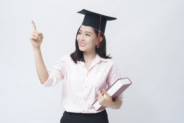 一个美丽的年轻亚洲女人的肖像与教育帽在白色的背景工作室，教育概念。图片下载