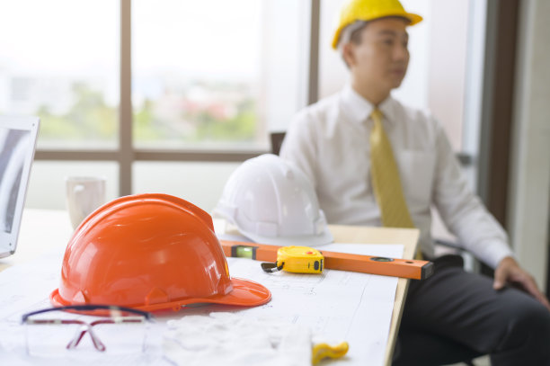 近距离展示红色头盔上的工程工作台，安全工作，工程师背景，工业经营理念图片下载